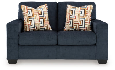 A close-up of the Ashley Furniture Aviemore loveseat showing plush beige fabric and padded armrests.