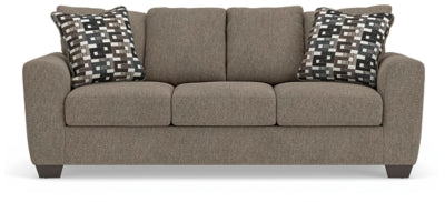 Ashley Furniture Triston-Peaks sofa with plush cushions and wooden legs, shown from head-on view in a modern living room setting.