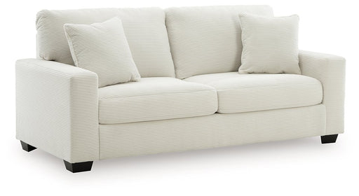 Ashley Furniture Greenbriar sofa in a green fabric, shown from an angled side view with plush cushions and wooden legs.