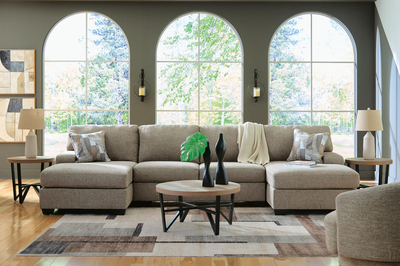 Ashley Furniture Newellen sectional with chaise, featuring plush cushions and neutral upholstery in a modern living room setting.