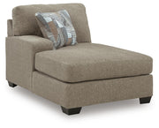 Ashley Furniture Newellen sectional with chaise, showing a modern fabric sofa with multiple cushions and a spacious chaise lounge.