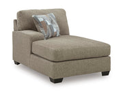 Ashley Furniture Newellen sectional with chaise, showing a modern fabric sofa with a spacious chaise lounge in a living room setting.