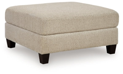 Ashley Furniture Steelwater Retreat oversized accent ottoman with plush fabric and sturdy wooden legs, shown from an angled view.