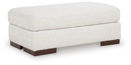 Ashley Furniture Hartside Ottoman with upholstered fabric and wooden block feet, shown from an angle.