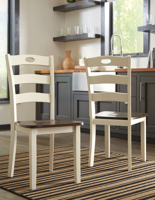 Set of Ashley Furniture Woodanville dining chairs with wooden legs and upholstered seats, arranged around a dining table.