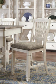 Ashley Furniture Bolanburg counter height bar stool with wooden legs and cushioned seat, shown in a modern home setting.