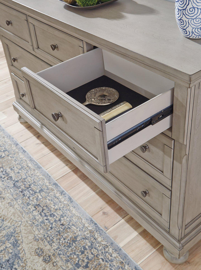 Ashley Furniture Lettner Dresser with multiple drawers, crafted in dark wood, featuring sleek metal handles and modern design elements.