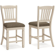 Ashley Furniture Bolanburg counter height bar stool with wooden legs and cushioned seat, shown in a modern kitchen setting.