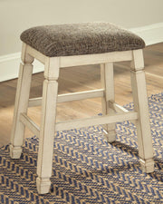 Counter height Ashley Furniture Bolanburg barstool with wooden legs and upholstered seat, ideal for kitchen or bar area.