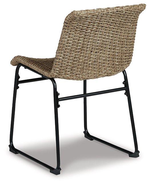 Two Ashley Furniture Amaris outdoor dining chairs with metal frames and beige cushions, set against a garden background.