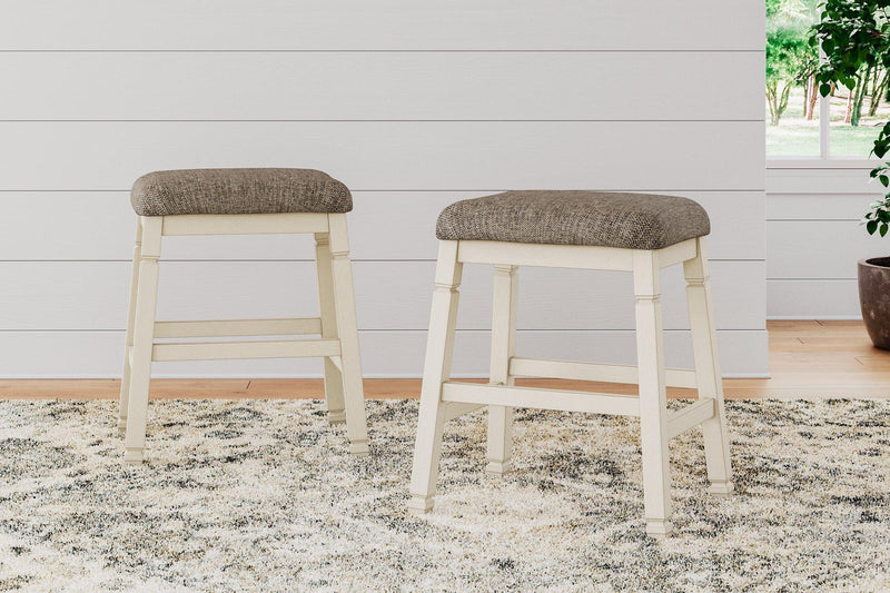 Ashley Furniture Bolanburg counter height bar stool with cushioned seat and wooden legs, shown in a modern kitchen setting