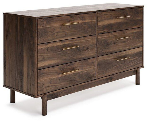 Ashley Furniture Calverson Dresser with multiple drawers and modern design, shown in a well-lit bedroom setting.