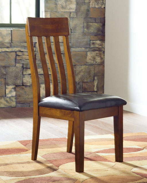 Set of Ashley Furniture Ralene dining chairs with upholstered seats and wooden legs, arranged around a dining table.