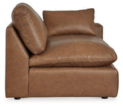 Emilia leather sectional by Ashley Furniture with attached chaise and matching ottoman, showcasing plush cushions and sleek design.