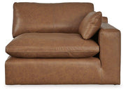 Ashley Furniture Emilia Sectional sofa with plush cushions and neutral upholstery, shown in a spacious modern living room.