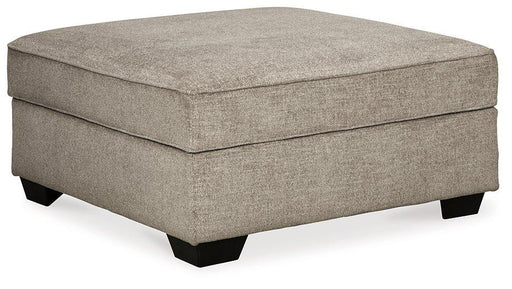 Ashley Furniture Bovarian Ottoman showing a plush upholstered surface with wooden legs and a classic design.