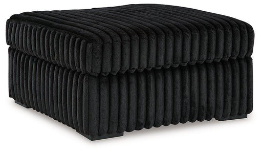 Oversized Ashley Furniture Midnight-Madness accent Ottoman with plush fabric and modern design, placed in a stylish living room setting.