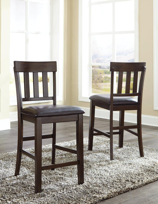 Set of two Ashley Furniture Haddigan Bar Stools with wooden legs and cushioned seats, suitable for kitchen or bar area.