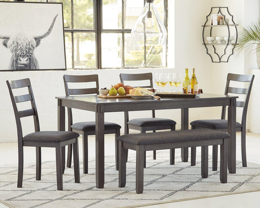 Ashley Furniture Bridson dining table with matching chairs and bench, showcasing a modern wood finish and sturdy design.