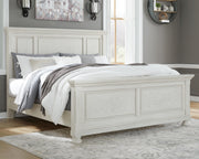 Ashley Furniture Robbinsdale bedroom set featuring a neatly made bed with a wooden headboard and matching nightstands in a cozy bedroom.