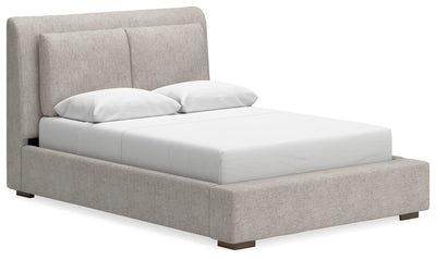 Ashley Furniture Cabalynn upholstered bed with a plush, tufted headboard and neutral fabric in a stylish angle view.