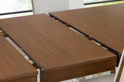 Detail of the Ashley Furniture Lyncott dining extension table showing the leaf mechanism and wooden finish.