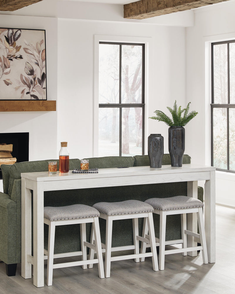 Ashley Furniture Robbinsdale counter height dining table with three matching barstools, showcasing a stylish wood finish and modern design.