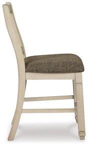 Ashley Furniture Bolanburg dining room set with a wooden table and matching chairs, shown from a side angle.