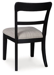 Ashley Furniture Greddinton dining chair with upholstered back and wooden legs, shown from the back in a stylish dining room setting.