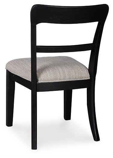 Ashley Furniture Greddinton dining chair with upholstered back and wooden legs, shown from the back in a stylish dining room setting.