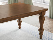 Close-up of the Ashley Furniture Greddinton dining room set with a wooden table and matching chairs, showcasing elegant craftsmanship.