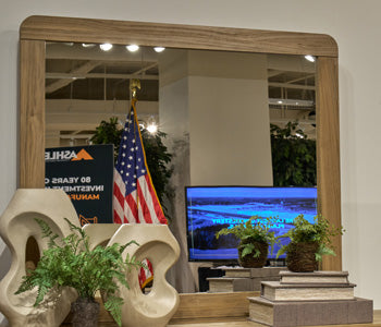 Ashley Furniture Gramburg bedroom mirror with a sleek rectangular frame, hanging on a wall in a modern bedroom setting.